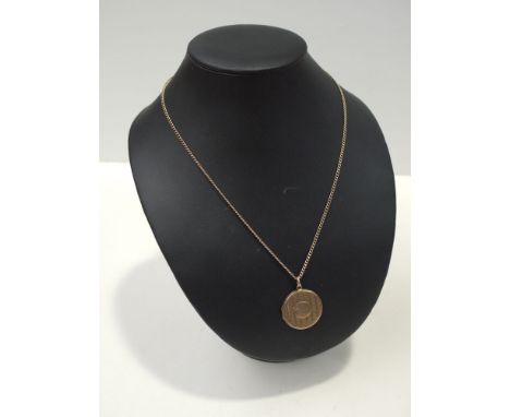 A 9ct. yellow gold circular locket pendant with engine turned decoration on a fine trace link chain, the clasps stamped 9ct.