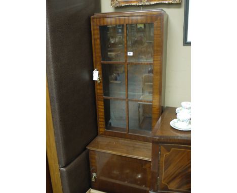 A small reproduction mahogany bookcase, with glazed panel enclosing shelves, fitted a cupboard in the base, raised on bracket