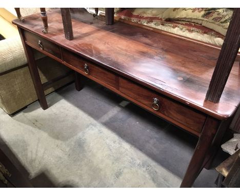 A hardwood side table, fitted three drawers with lion’s  mask ring handles, 149cm wide