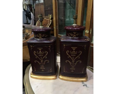 A pair of ceramic lamp bases, modelled as Chinese tea canisters, with painted classical foliate motifs to a maroon ground, 47