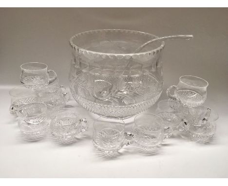 A glass punch bowl, circular form with cut, etched and polished roundels, with ladle and twelve matching punch cups
