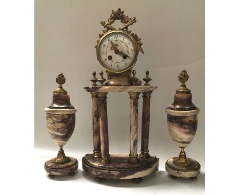 A French marble eight day striking portico mantel clock, brass cased drum movement surmounted with floral wreath and torches,