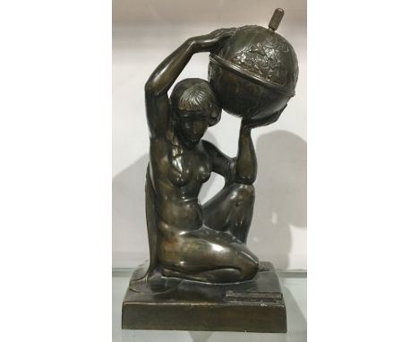 An Art Deco patinated art metal figural table lighter, modelled as a kneeling nude woman holding a globe, 24cm high