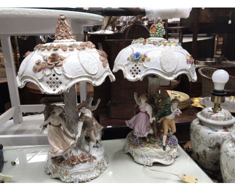 A 19th century continental porcelain lamp base modelled as figures dancing around a tree, with reticulated floral encrusted s