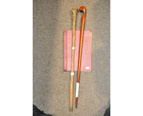 A walking stick, made from a WWI plane strut, another walking stick and WWII training notes