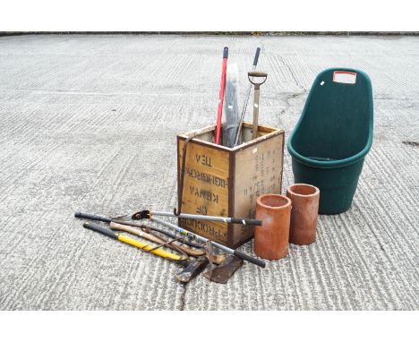 A selection of tools and a terracotta pipe