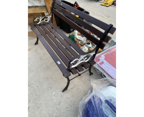 A WOODEN SLATTED GARDEN BENCH WITH CAST BENCH ENDS 
