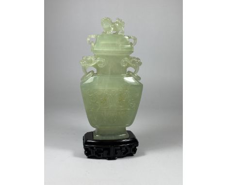 A DECORATIVE ORIENTAL JADE TYPE HARDSTONE LIDDED VASE ON WOODEN BASE, HEIGHT 19CM 