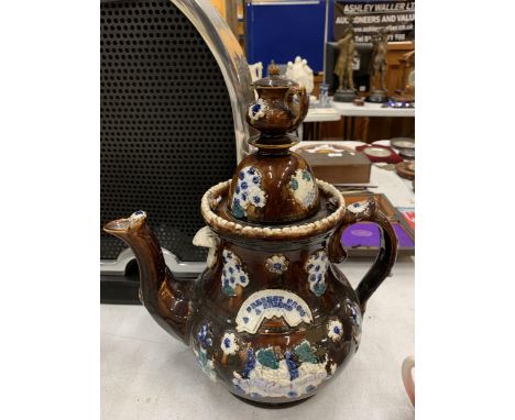 A LARGE TREACLE GLAZED BARGEWARE TEAPOT - A/F HEIGHT APPROX 33CM 