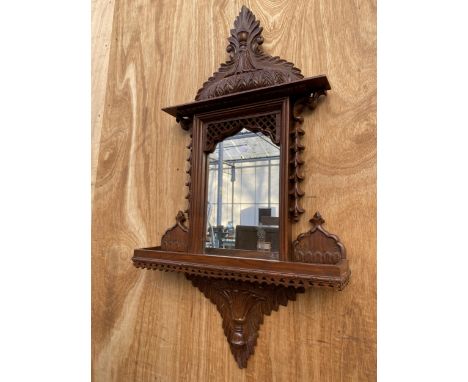 A DECORATIVE WOODEN FRAMED WALL MIRROR WITH LOWER SHELF 