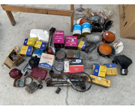 A LARGE ASSORTMENT OF VINTAGE AUTOMOBILE SPARES TO INCLUDE FILTERS, MIRRORS, LIGHTS AND REFLECTORS ETC 