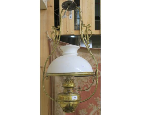 A brass hanging oil lamp with white shade Condition Report: Available upon request
