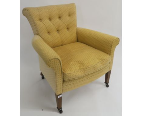 A yellow button back upholstered armchair with square tapering legs on ceramic castors, 84cm high Condition Report: Good over