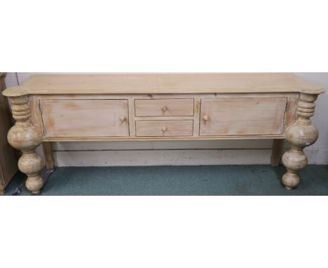 A modern limed pine console table with two drawers flanked by two doors with baluster shaped supports, retailed by Design Wor