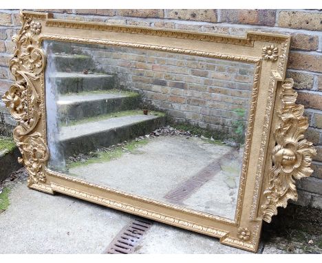 George II style giltwood and gesso mirror with a scrolling crest and winged cherub;s head apron