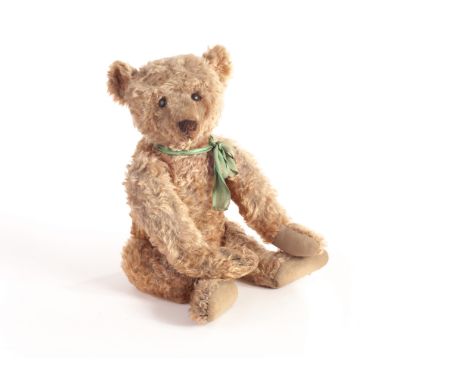 An early Steiff Teddy Bear, circa 1909, with dark golden mohair, black boot button eyes, pronounced clipped muzzle, black sti