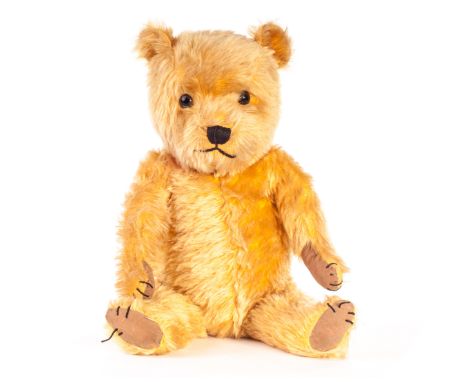 A post-war Chiltern Hugmee Teddy Bear, with golden mohair, replaced eyes, black stitched nose, mouth and claws, swivel head, 