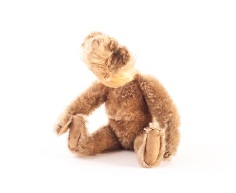 An early Steiff Teddy Bear (faceless), circa 1910, with golden mohair, ears, jointed limbs with felt pads, black stitched cla