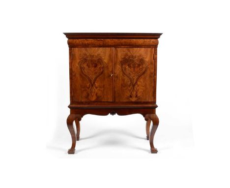 A burr walnut cabinet on stand, with 18th Century elements, the rectangular top with long cushion drawer above a pair of pane