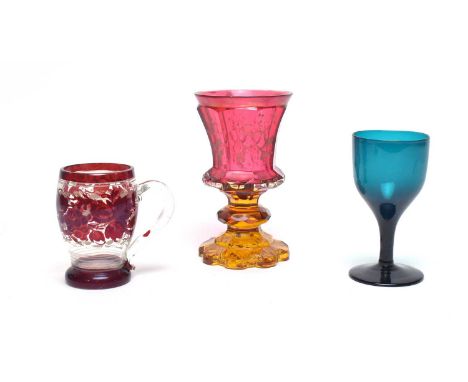 A Bohemian cranberry and amber glass goblet, 19th century, with gilt foliate decoration, 14.5cms; a ruby flash cup, 9cms; and