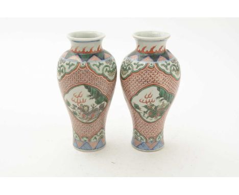 A pair of Chinese Wucai vases, probably 19th century, of baluster form, decorated with panels of dragons on an iron-red scale