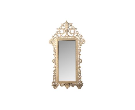 A large decorative carved softwood wall mirror in the Baroque taste, with pineapple decoration to the top and with 'C' scroll