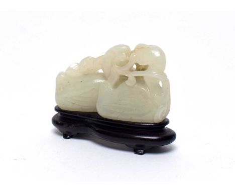 A pale green jade pebble carving in the form of two mandarin ducks and water lilies, Qing, 7cms, wood stand.