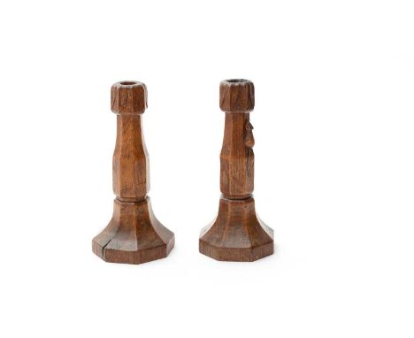 Robert Mouseman Thompson of Kilburn, a pair of carved oak candlesticks, probably 1930s, the carved leaf motif to the nozzles,