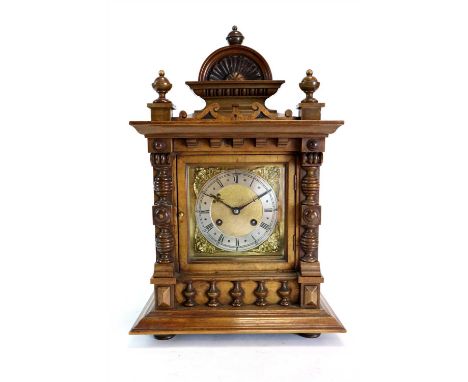 A 19th century German walnut cased bracket clock, the silvered dial with black Roman numerals framed by gilded pierced cherub