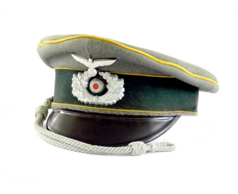 A German Third Reich Army Cavalry Officer’s visor cap by EREL the cap constructed of a field grey doeskin with yellow piping 