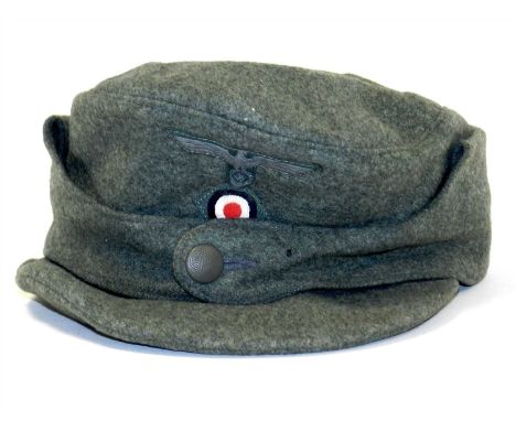 A German Third Reich Army Other Ranks Officer’s M43 ski/field cap constructed of field grey woollen body and affixed with two