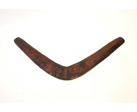A rustic hand-carved wood boomerang, believed to be Australian (Aboriginal) 19th or 20th century, of typical form, with a rus