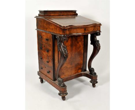 A Victorian figured walnut davenport with lift top stationary compartment above a leather-lined writing slope enclosing a map