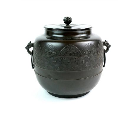 A large Japanese Meiji period lidded bronze vessel, of footed cylindrical form, the bowl ringed with three collars centred wi
