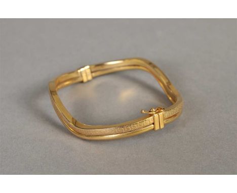 A 9ct gold stylised wave hinged bangle, with twin pin clasp and attached safety catch, weight approx 8.2g