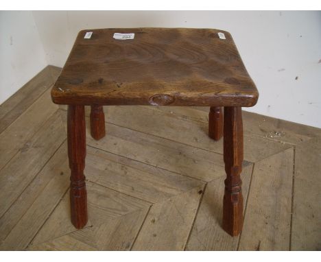 Early oak 'Acorn Man' milking style stool with rectangular adzed top on four supports (30cm x 21cm x 32cm)