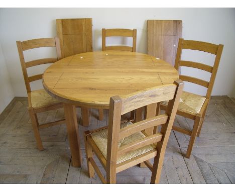 Light oak circular extending dining table with two additional leaves and a set of four ladder back rush seated chairs (min 10