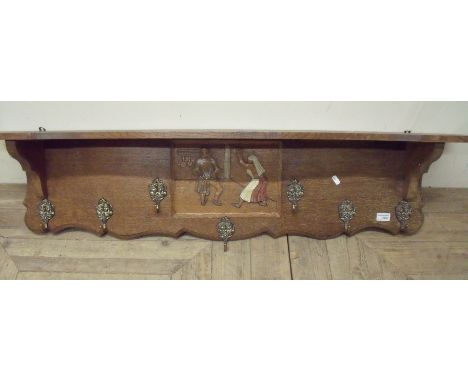 Continental carved oak wall shelf with hat and coat hooks with central carved panel of couple (width 120cm)