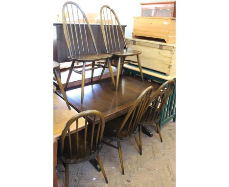 A set of six dark Ercol dining chairs and an extending dining table