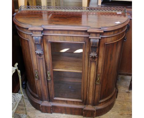 An Victorian bow fronted glazed display cabinet with brass gallery upstand