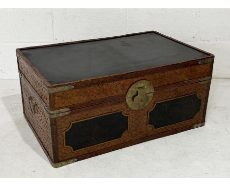 A Japanese wicker trunk with etched decoration to lid showing traditional scenes 
