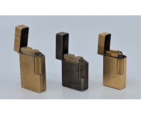 An S.T.Dupont gold plated cigarette lighter, together with an S.T.Dupont silver plated cigarette lighter and a Flaminaire gol
