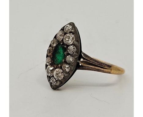 A yellow and white metal, diamond and emerald ring, the marquise shape mount set mixed oval cut emerald to centre bordered by