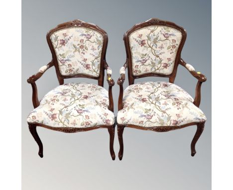 A pair of carved beech open salon armchairs upholstered in a tapestry fabric. 