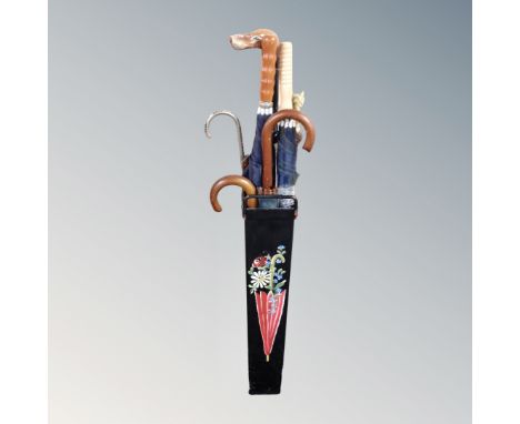 A hand-painted metal stick stand containing umbrellas and walking sticks to include dog's head example. 