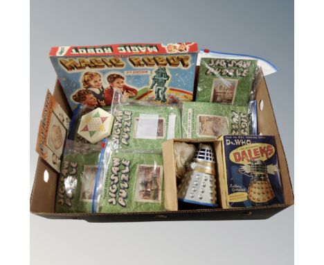 A box containing vintage interlocking puzzles, a Dr Who battery operated dalek box, a robot magic game etc. 