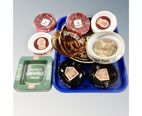 Nine 20th century ceramic glass and metal pub ash trays together with a Tuborg tin serving tray. 