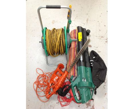 A Hozelock hose pipe on reel together with a Qualcast leaf blower, a Flymo hedge trimmer and a hammock. 