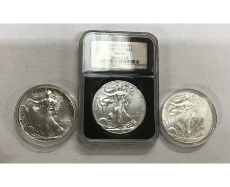 NSG Slabbed American Walking Liberty 1oz Fine Silver Coin of 2014, with two more in capsules dated 1993 and 2010.
