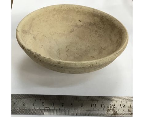                         Roman pottery dish of a light cream colour. It is 126 mm diameter and 44 mm high. It is undecorated w